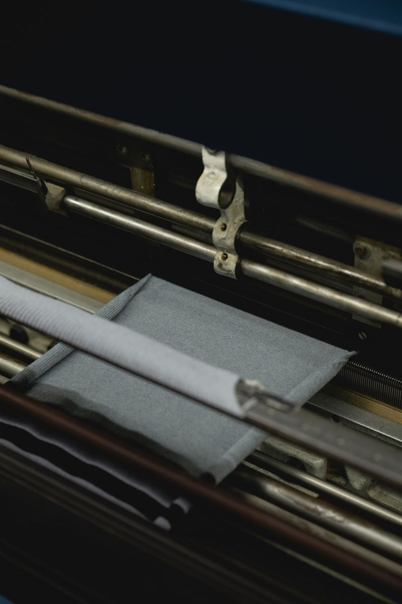 Close-up of grey knit on the knitting frame
