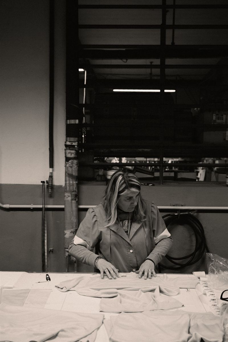 A worker checks and prepares garments with their labels